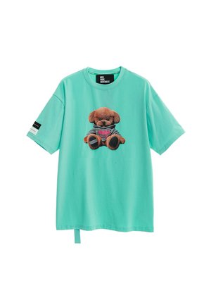 Camiseta turquesa de manga corta con un oso de peluche con capucha gris impreso en el frente y un pequeño parche en blanco y negro en la manga.