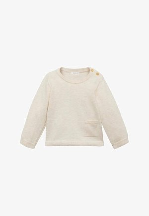 Vaaleanbeige pitkähihaisen taaperopaidan kanssa, jossa on pyöreä kaula-aukko, tekstuuri kangasta, pieni etutasku ja kaksi koriste nappia olkapäällä.