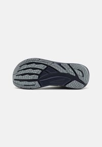 Sport shoe sole, dark blue rubber with a textured gray tread pattern. Features deep grooves and flexible sections for traction and movement.
