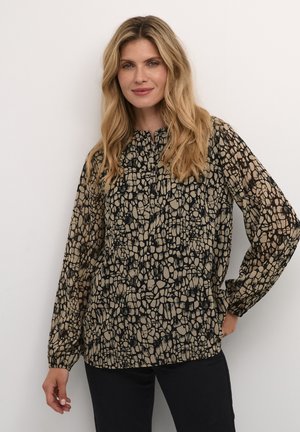 Blus med långa ärmar som har ett svart och beige abstrakt mönster, tillverkad av lättviktig textil med rundad halsringning och samlad detalj.