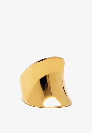 Anello color oro con una superficie liscia e lucida. Presenta un design scolpito con una forma curva e contorni distinti e ondulati.