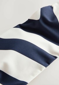 Tkanina u mornarskoj plavoj i bijeloj prugastoj izvedbi, glatke teksture, s odvažnim horizontalnim prugama različitih širina. Dizajnirana za svestranost i udobnost.