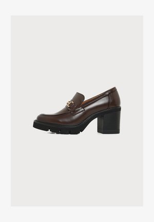Καφέ δερμάτινο loafer με chunky τακούνι, χρυσή αγκράφα και μαύρη χοντρή σόλα με πέλμα.
