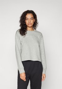 Šedá zkrácená mikina z měkké tkaniny s kulatým výstřihem a dlouhými rukávy. Obsahuje logo Calvin Klein v jemném tón v tónu designu.