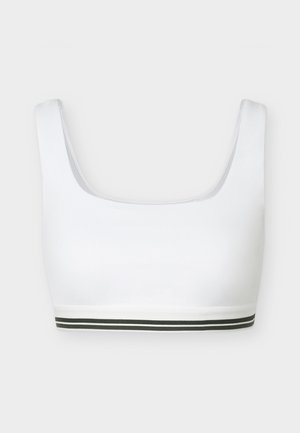 Λευκό αθλητικό σουτιέν με φαρδιές τιράντες ώμου και διπλή μαύρη ρίγα κατά μήκος του κάτω μέρους της ταινίας, εμφανίζεται σε ανοιχτό γκρι φόντο.