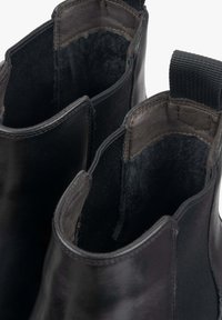 Czarne skórzane botki za kostkę z elastycznymi bocznymi panelami, gładką teksturą, miękką podszewką i detailami w postaci pętli z tyłu.