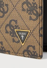 Barna mintás pénztárca texturált felülettel, aranyszínű háromszög alakú logóval és fekete részletekkel. Kompakt kialakítás varrott élekkel.