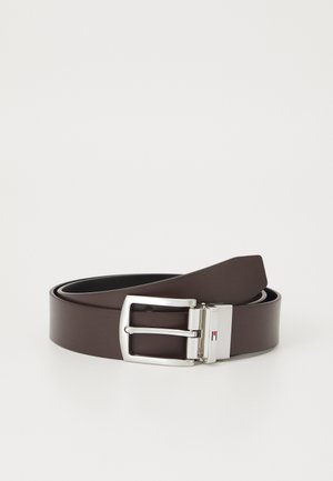 Brauner synthetischer Gürtel mit einer silbernen Metallschnalle, die eine rechteckige Form und eine glatte Oberfläche aufweist. Die Schnalle enthält ein dezentes Logodetail.