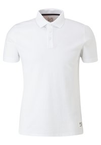 Polo blanc à manches courtes avec trois boutons et une petite étiquette près de l'ourlet inférieur sur un fond uni.