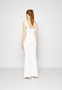 Vestido branco ajustado com um design elegante, apresentando alças com rendas e costas baixas. O tecido é suave, acentuando uma silhueta minimalista.