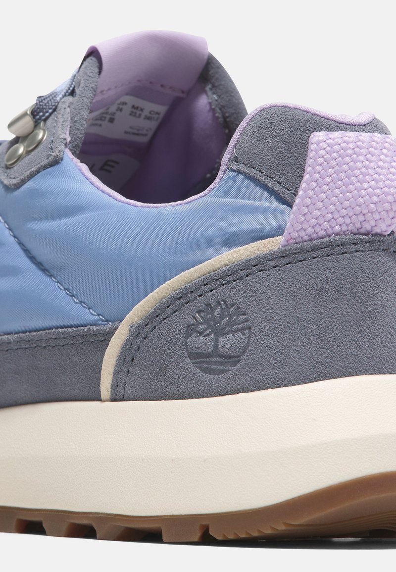 Sneaker blu e grigio con tomaia in suede e nylon, accenti viola testurizzati, collo imbottito e suola in gomma con logo ad albero.