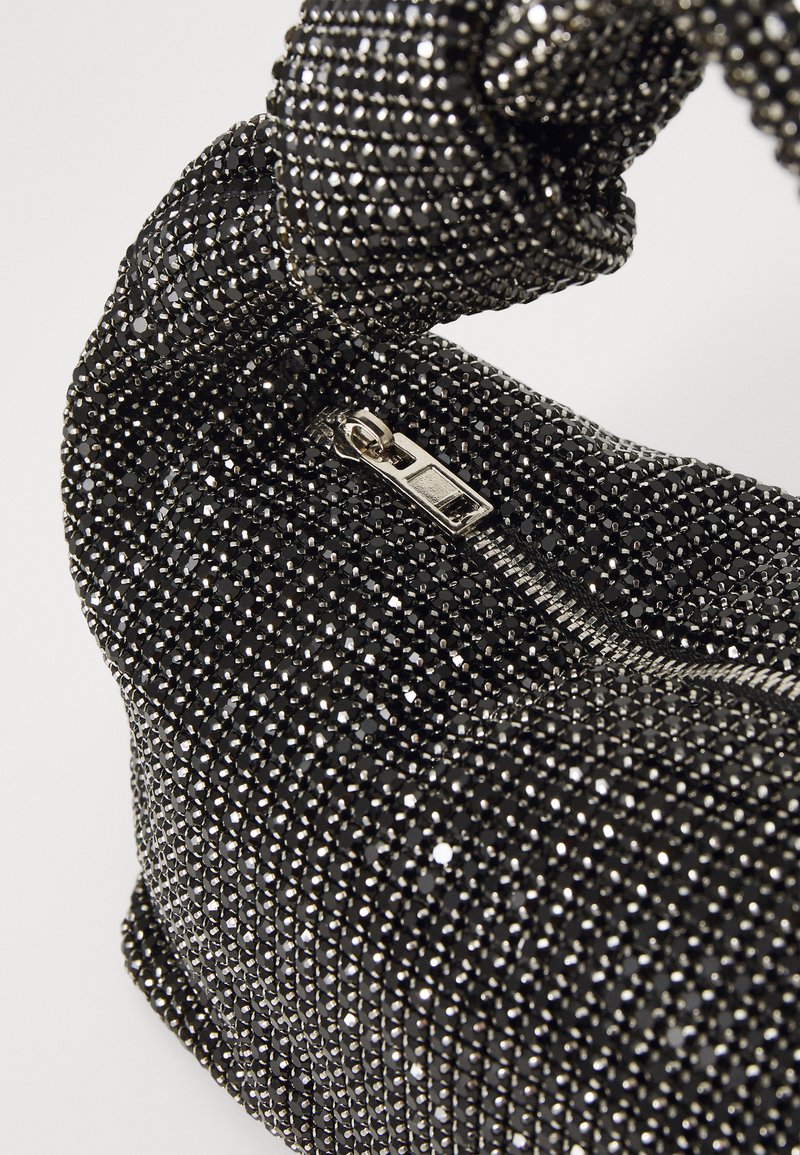 Borsa a pochette nera ricoperta di piccoli strass sfaccettati. Presenta una chiusura con zip e un manico intrecciato, che riflette la luce dalla sua superficie texture.