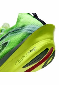 Nike Road Racing AF schoen met een felgroene gebreide bovenkant, een kenmerkende hielvorm en gestructureerde accenten; zwart en rood details op de zool.