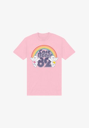 T-shirt di cotone rosa con un grafico che presenta due Care Bears, un arcobaleno e il numero "82" in caratteri in grassetto, con un design retrò.