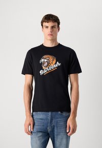 Tricou negru din bumbac, decorat cu o grafică a unui tigru feroce în portocaliu și alb, având textul "Barbour International" dedesubt.
