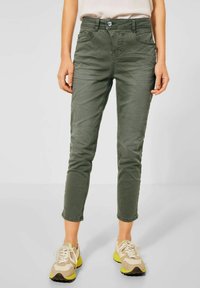 Khaki bawełniane chinosy o slim fit, pięć kieszeni i guzikowe zapięcie. Cechuje ich podwinięta nogawka i teksturowane wykończenie. Idealne do codziennych stylizacji.