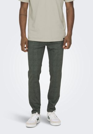 Groene geruite broek in een getailleerde pasvorm. Gemaakt van geweven stof met een gestructureerd oppervlak. Gecombineerd met witte sneakers en een licht T-shirt.