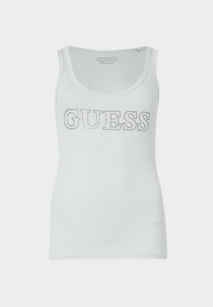 White ribbed tank top featuring a rounded neckline and a silver glitter "GUESS" logo across the chest. Soft, stretchable fabric.