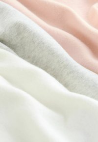 Trzy nakładające się kawałki materiału: delikatny róż, jasny szary i biały. Miękka tekstura, gładka powierzchnia, lekki, lekko melanżowy szary.