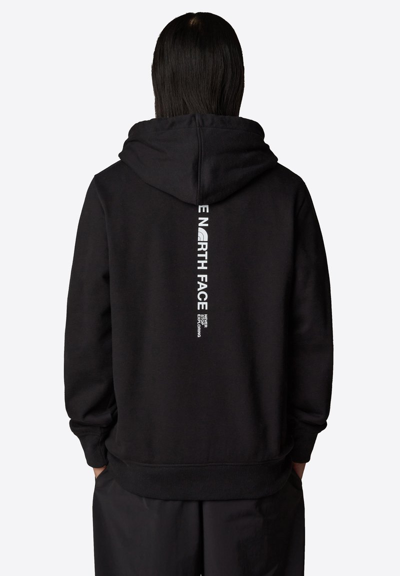 Svart hoodie med en stor logotyp på ryggen i vit text. Mjuk, strukturerad tyg med en avslappnad passform och ribbade muddar och nederkant.