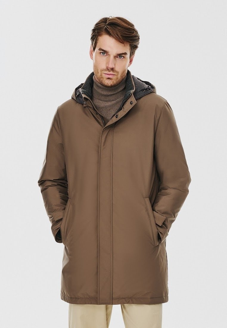 Brązowy ocieplany płaszcz z kapturem, z gładką powierzchnią, z przodu na zamek i bocznymi kieszeniami. Noszony na szary golf.