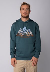 Sweat à capuche teal avec un motif de montagne dans des teintes de bleu, marron et crème. Il possède une poche avant et des cordons de serrage à la capuche.