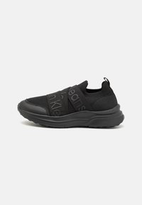 Sneaker sportive nere con tomaia in rete, doppiose cinghie regolabili, suola testurizzata e pull tab sul tallone per indossarle facilmente.