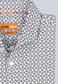 Weißes Hemd mit einem schwarz-blauen Kettenmuster, ausgestattet mit einem orangefarbenen Etikett und Knopfverschlüssen. Reguläre Passform mit einem Kragen.