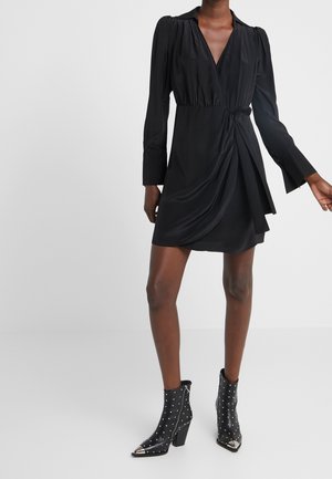 Sort omslagskjole med lange ærmer, V-halsudskæring og bælte i taljen. Glat stof, knudedetalje i siden og flydende nederdel.