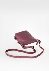 Borsa a tracolla rettangolare in pelle bordeaux con tracolla regolabile. Presenta una chiusura superiore con cerniera e una texture liscia e opaca.