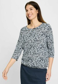 Marineblaue Bluse mit floralem Muster, dreiviertel Ärmeln, Rundhalsausschnitt und einem kleinen Schlüssellochdetail vorne. Weicher Stoff mit strukturierter Haptik.
