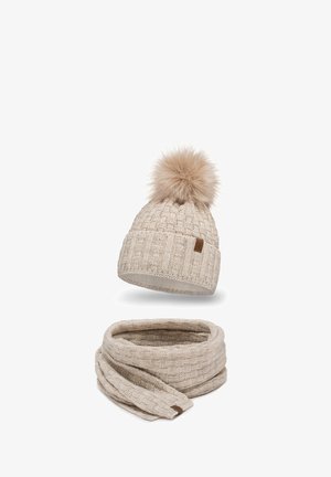 Beige knitted hat with a fur pom-pom and matching scarf featuring a textured pattern. Both items display a soft, cozy appearance.