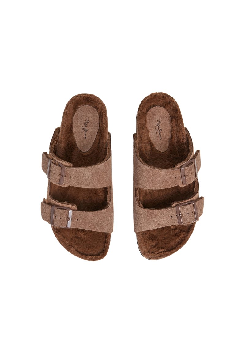 Braune Wildledersandalen mit zwei verstellbaren Riemen, einem kuscheligen Innenfutter und einer flachen Sohle. Ausgestattet mit silberfarbenen Schnallen und einer abgerundeten Form.