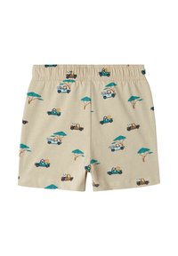 Beige bomulds shorts med et legende print af dyr i lastbiler og træer. Elastisk talje, letvægtig og glat tekstur.