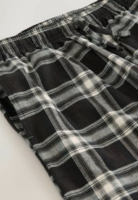 Sort-hvid ternet loungewear shorts med blødt stof, elastisk talje og kontrasterende ternede mønstre med elegante detaljer.
