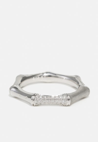 Silver ring with a textured, angular design. Center features a row of small, clear stones. Smooth and polished edges enhance detail.