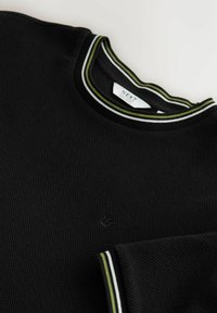 Pull en maille noir avec col et poignets rayés verts et blancs, étiquette intérieure du col indiquant "Next Regular Fit".
