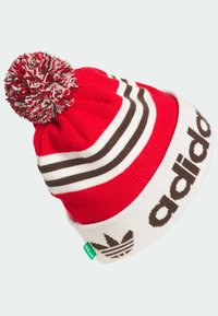 Rød strikket hue med en hvid kant, der har brune striber og "adidas" logo; toppet med en multicolor pompon.