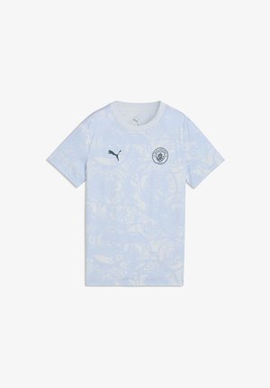 Lichtblauw Manchester City voetbalshirt met subtiele cirkelvormige patronen, Puma-logo op de rechterborst en clubwapen op de linkerborst.