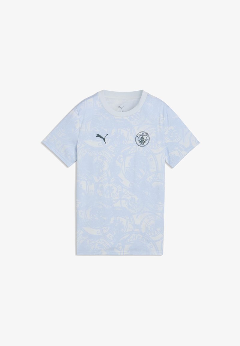 Camiseta de fútbol del Manchester City de color azul claro con sutiles patrones circulares, logo de Puma en el pecho derecho y escudo del club en el pecho izquierdo.