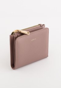Cartera con cremallera de color marrón claro, hecha de material texturizado, que cuenta con un tirador de cremallera dorado y un sutil logo de la marca en la parte frontal. Forma rectangular compacta.