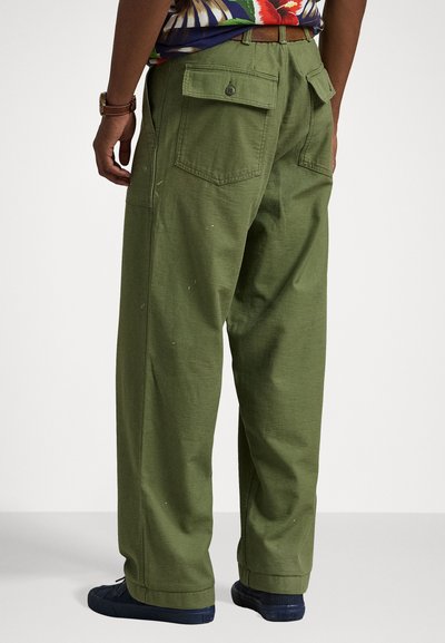 Pantalones cargo verdes con un corte holgado, hechos de un tejido duradero. Presenta dos bolsillos traseros y detalles de costura visibles.