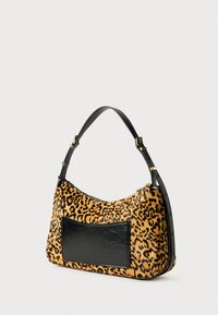 Τσάντα χειρός με καμηλοπαρδάλεις σχέδιο, φτιαγμένη από υφασμάτινη υφή, διαθέτοντας μια μαύρη δερμάτινη τσέπη και μια καμπυλωτή, ρυθμιζόμενη μαύρη strap.