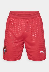 Κόκκινα αθλητικά σορτς με υφασμένο σχέδιο, με λευκό λογότυπο Puma και το έμβλημα της Πορτογαλίας στο αριστερό πόδι. Περιλαμβάνεται ελαστική ζώνη μέσης.