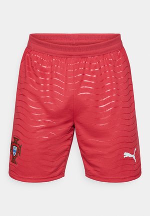 Czerwone sportowe spodenki z teksturowanym wzorem, z białym logo Puma i herbem Portugalii na lewej nodze. Posiadają elastyczną talię.