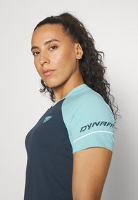 Αθλητικό μπλουζάκι κοντού μανικιού με ναυτικό σώμα και ανοιχτό μπλε λεπτομέρειες, υφασμάτινη υφή και λογότυπο στο δεξί μανίκι.