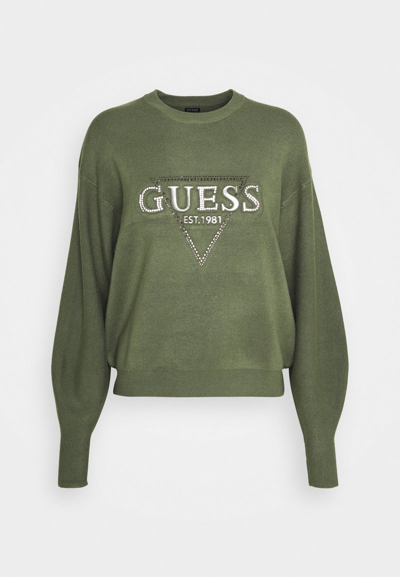 Oliwkowy sweter z miękkiej dzianiny, o szerokim kroju, długich rękawach i trójkątnym logo "GUESS" ozdobionym cyrkoniami.