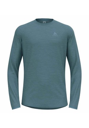 Long-sleeve active shirt in muted teal, made of textured fabric. Features a round neckline and subtle logo on the front.