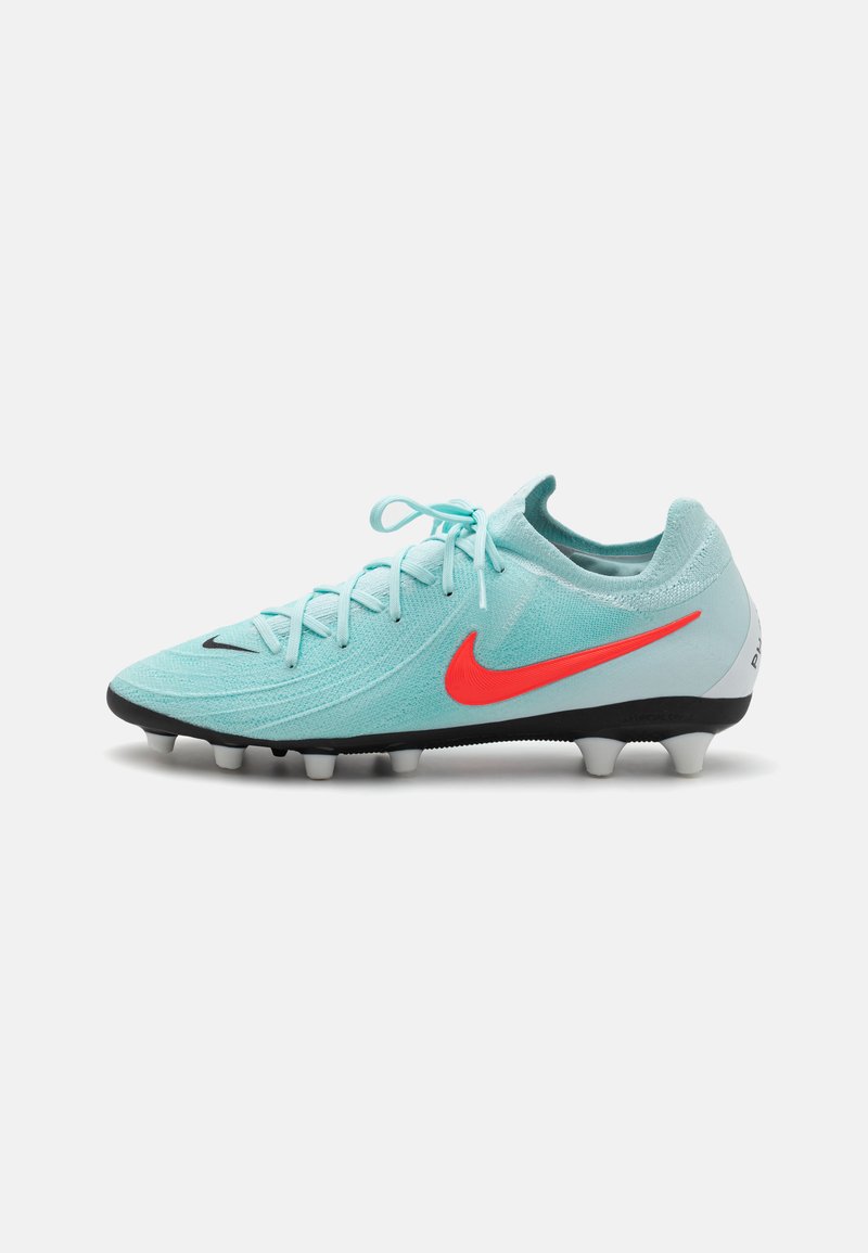 Football boot in teal mesh material with red Nike swoosh; features a lightweight design, lace-up closure, and black sole with white studs.