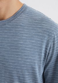 Blau-weiß gestreiftes T-Shirt mit Rundhalsausschnitt, aus weichem Stoff gefertigt, mit feinen horizontalen Linien und einer glatten Textur.